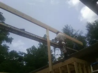 Carpenter setting a ridge beam over a new addition frame — Ice Dam Removal by Roofing Brothers in Kittery Point
