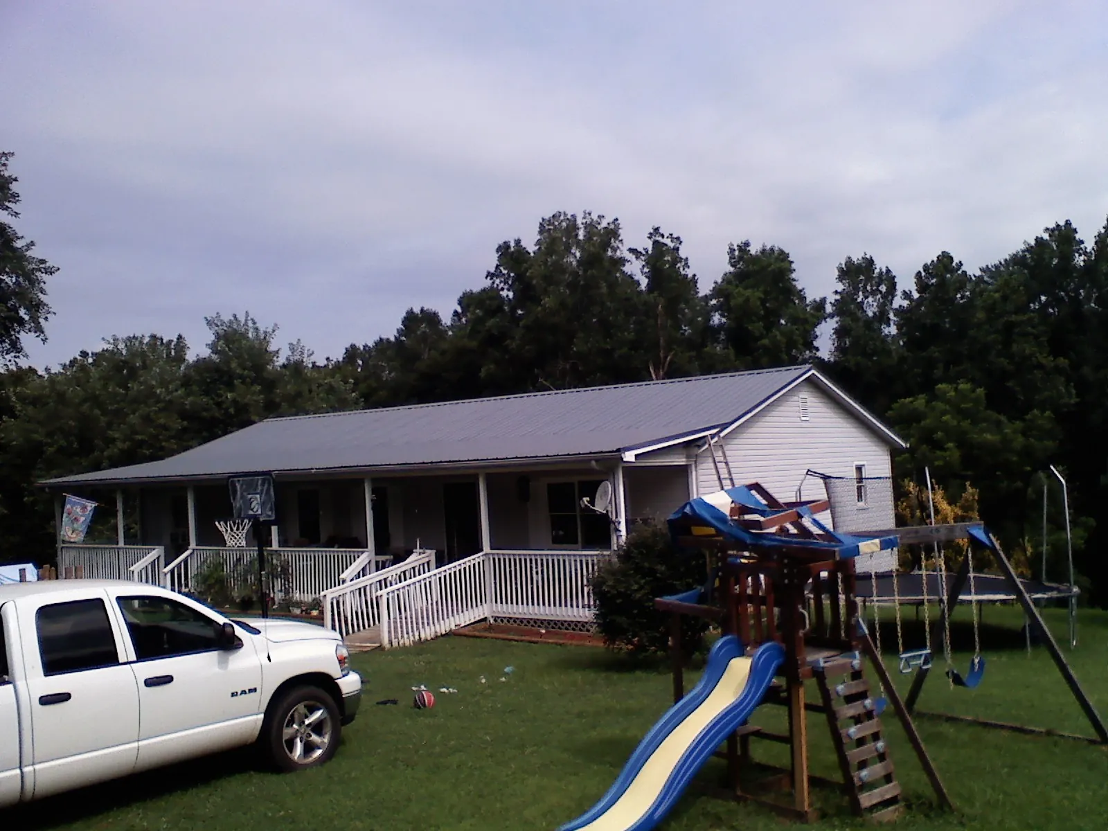 Dark metal roof on a country home with a full length front porch in Kittery Point