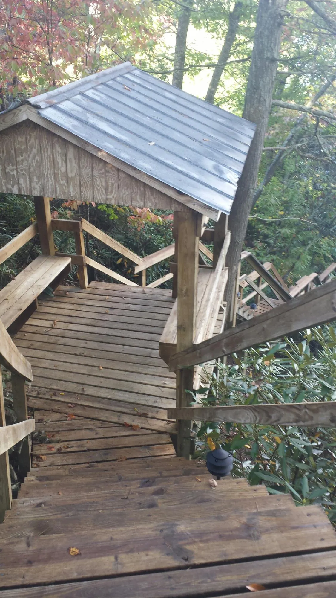 Metal roofed shelter over wooden steps on a wooded walkway — Skylight Repair & Installation work by our crew in Kittery Point