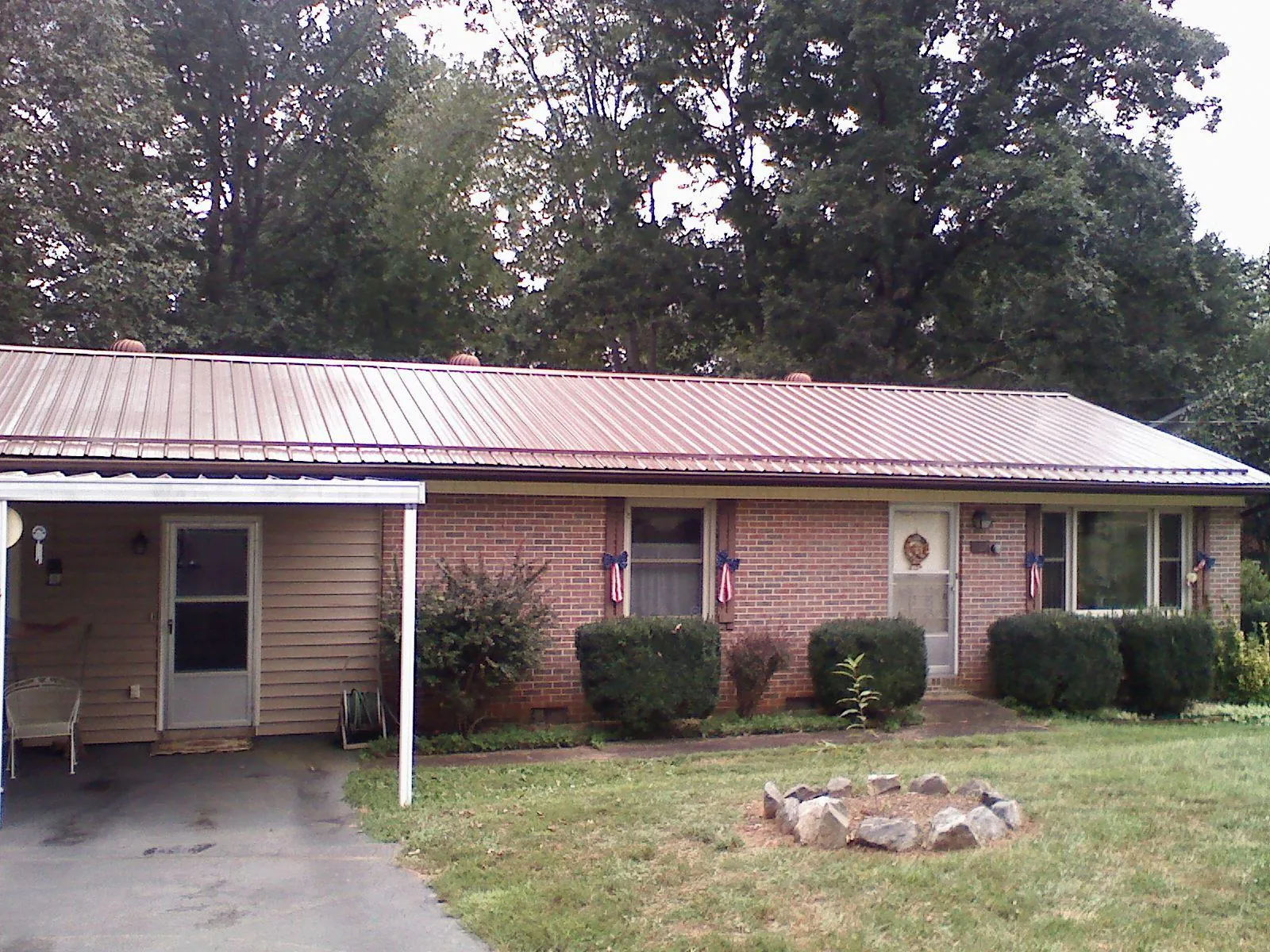 Bronze metal roof and carport on a brick ranch home — Roof Repair work by our crew in Kittery Point